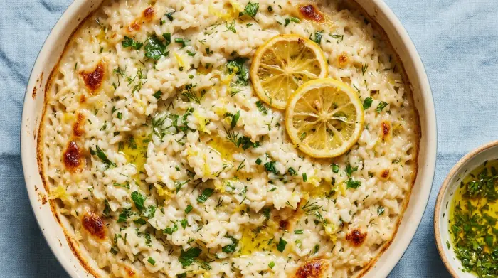 A serving of creamy lemon and herb baked risotto in a shallow bowl.