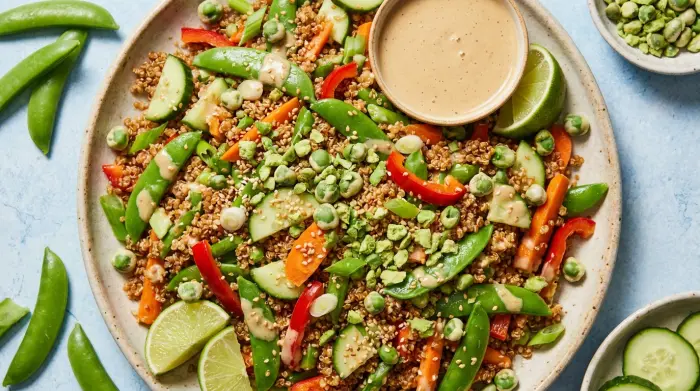 A large bowl of quinoa salad topped with crushed wasabi peas.
